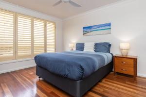 a bedroom with a bed and a dresser and a window at 36 Churchill in Forster +8 photos
