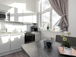 eine Küche mit weißen Geräten, einem Tisch und einem Fenster in der Unterkunft Two-Bedroom Holiday home in Wendtorf 17 in Wendtorf