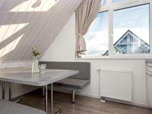 ein Esszimmer mit einem Tisch und einem Fenster in der Unterkunft Holiday Home Strandblick in Wendtorf