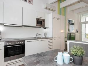 a kitchen with white cabinets and a table with mugs at 6 person holiday home in Wendtorf in Wendtorf
