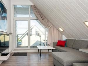 a living room with a couch and a large window at Holiday Home Strandblick in Wendtorf