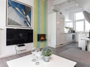 ein Wohnzimmer mit einem Kamin und einem Tisch mit Weingläsern in der Unterkunft Two-Bedroom Holiday home in Wendtorf 20 in Wendtorf