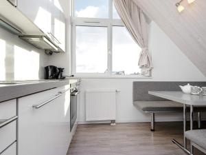 eine weiße Küche mit einem Tisch und einem Fenster in der Unterkunft 6 person holiday home in Wendtorf in Wendtorf