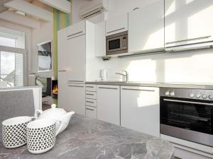 eine Küche mit weißen Schränken und einer Arbeitsplatte in der Unterkunft 6 person holiday home in Wendtorf in Wendtorf