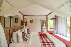 a bedroom with a bed with a canopy at Villa Ubud Sunshine in Ubud