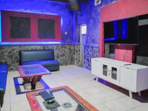 Urbanview Hotel Rio Life House Cianjur by RedDoorz في سيانجور: غرفة معيشة مع أريكة وتلفزيون