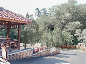 un pavillon dans un parc avec des arbres en arrière-plan dans l'établissement Urbanview Hotel Rio Life House Cianjur by RedDoorz, à Cianjur