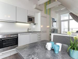 una cocina con armarios blancos y una mesa con tazas. en 4 person holiday home in Wendtorf, en Wendtorf