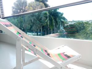 a lounge chair on a balcony with a view of palm trees at MALALA3 depa amoblado in Sincelejo
