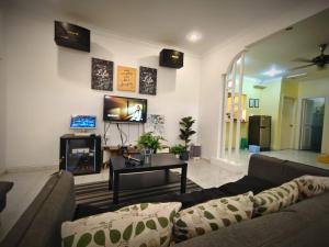 un salon avec un canapé et une télévision dans l'établissement Melaka AFamosa Pool Villa 5 Bedroom Moments Villa Lot 1319 Homestay, à Kampong Pulau Sebang