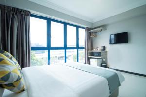 pokój hotelowy z łóżkiem i dużym oknem w obiekcie Harbour Ville Hotel w Singapurze
