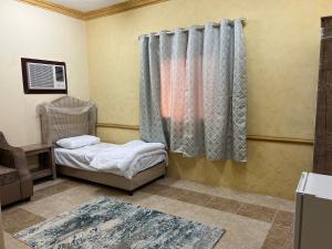 a small room with a bed and a curtain at سويتات مفروشة in Al Hofuf