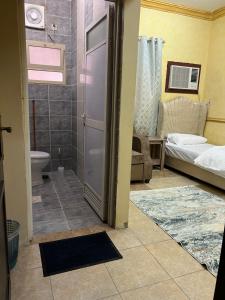 a bathroom with a shower and a toilet and a door at سويتات مفروشة in Al Hofuf
