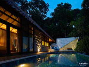 a villa with a swimming pool at night at Arumdalu Private Resort in Membalong