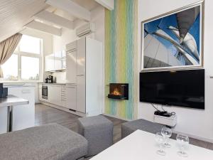 a living room with a tv and a fire place at Holiday Home Strandblick IV in Wendtorf