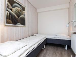 シュタインにあるHoliday Home Strandblick IVのベッド2台が備わる客室で、壁には絵画が飾られています。