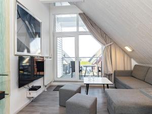 ein Wohnzimmer mit einem Sofa und einem TV in der Unterkunft Holiday Home Strandblick IV in Stein