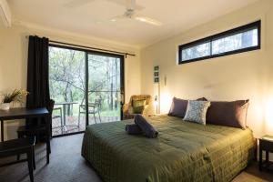 Un dormitorio con una cama y un escritorio y una ventana. en BIG4 Carnarvon Gorge Holiday Park, en Carnarvon Gorge