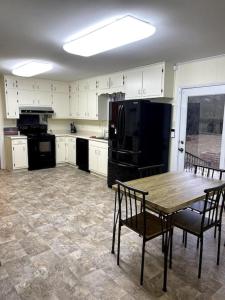 a kitchen with a wooden table and black appliances at You won't want to leave! in Huntsville