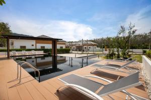 eine Terrasse mit Stühlen und einem Pool in der Unterkunft Villa Sunrise Garden A181 in Ban Muang Mai
