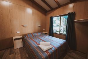 a small bedroom with a bed and a window at BIG4 Breeze Holiday Parks - Cania Gorge in Cania