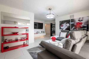 ein Wohnzimmer mit einem grauen Sofa und roten Regalen in der Unterkunft Lakefront Duplex with Pool between Miami & Florida Keys 4 Bedroom 2 Bathroom in Cutler Bay