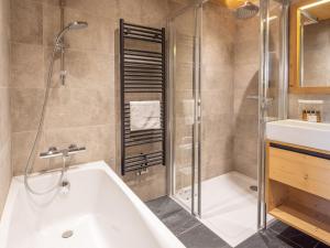 une salle de bain avec une baignoire, une douche et un lavabo dans l'établissement Ski-in/Ski-out à l'Alpe d'Huez: Appartement 130m² avec Piscine, Sauna et Hammam - FR-1-645-21, à Huez