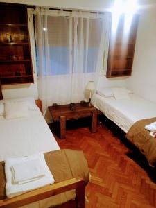 Habitación pequeña con 2 camas y mesa. en APARTAMENT - THE HARMONY - in the heart of Palermo - NEAR ALTO PALERMO SHOPPING en Buenos Aires