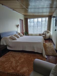 a bedroom with two beds and a large window at Casa Encanto Homestay in Shillong