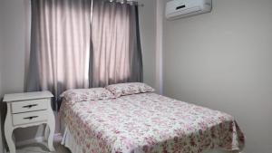 1 dormitorio con 1 cama, vestidor y ventana en Apto em BC Temporada Próx av Atlãntica, en Balneário Camboriú