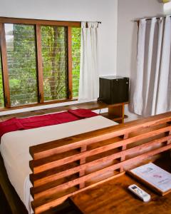 a bedroom with a bed and a tv and windows at Selá Nicaragua in El Gigante