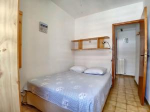 a bedroom with a bed with two pillows on it at Appartement Saintes-Maries-de-la-Mer, 2 pièces, 4 personnes - FR-1-475-32 in Saintes-Maries-de-la-Mer