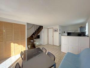 cocina y comedor con mesa y sillas en Appartement Saintes-Maries-de-la-Mer, 3 pièces, 6 personnes - FR-1-475-29, en Saintes-Maries-de-la-Mer