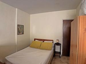Appartement Saintes-Maries-de-la-Mer, 1 pièce, 4 personnes - FR-1-475-34 في سانت ماري دو لا مير: غرفة نوم صغيرة مع سرير مع وسائد صفراء