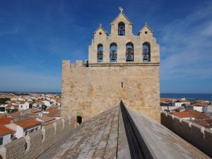 Un edificio alto con una torre dell'orologio sopra. di Appartement Saintes-Maries-de-la-Mer, 1 pièce, 4 personnes - FR-1-475-34 a Saintes-Maries-de-la-Mer