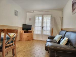 a living room with a couch and a tv at Appartement Saintes-Maries-de-la-Mer, 2 pièces, 6 personnes - FR-1-475-23 in Saintes-Maries-de-la-Mer