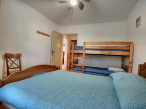 a bedroom with two bunk beds and a blue bed at Appartement Saintes-Maries-de-la-Mer, 2 pièces, 6 personnes - FR-1-475-23 in Saintes-Maries-de-la-Mer
