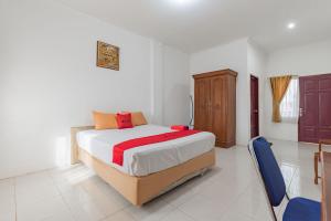 a bedroom with a bed and a wooden cabinet at RedDoorz near Samarinda Square in Samarinda