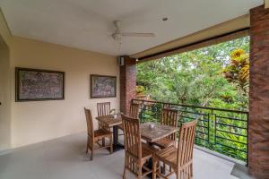 a dining room with a table and chairs and a balcony at Villa Ubud Sunshine in Ubud