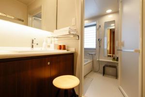 bagno con lavandino, servizi igienici e sgabello di Hotel Nara Sakurai No Sato a Sakurai