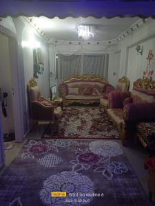 ein Wohnzimmer mit einem Bett, einem Sofa und Stühlen in der Unterkunft Cash and cash only please in ‘Izbat al Qaşr