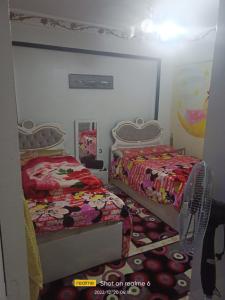 1 Schlafzimmer mit 2 Betten und einem Spiegel in der Unterkunft Cash and cash only please in ‘Izbat al Qaşr