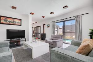 Μια τηλεόραση ή/και κέντρο ψυχαγωγίας στο Modern shared 5 BR Villa Pool near Blouberg Beach Wi-Fi