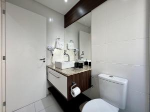 a bathroom with a white toilet and a sink at Apartamentos Onze1 no CENTRO by Achei Gramado in Gramado +65 photos