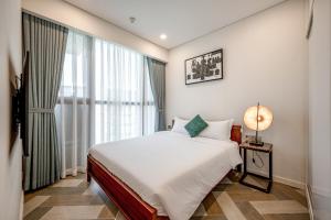 1 dormitorio con cama y ventana grande en The Metropoles - Sy's Home, en Ho Chi Minh