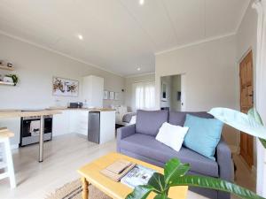 a living room with a couch and a table at Upmarket off grid cottage on organic farm in secure estate in Howick