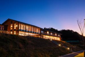 una casa in cima a una collina di notte di Hotel Nara Sakurai No Sato a Sakurai