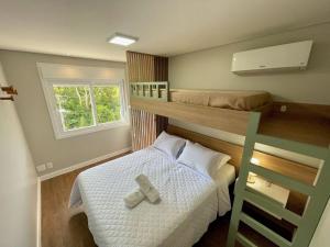 a small bedroom with a bunk bed and a ladder at Apartamentos Quinta do Palácio by Achei Gramado in Canela
