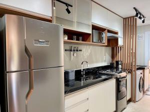 a kitchen with a stainless steel refrigerator at Apartamentos Quinta do Palácio by Achei Gramado in Canela