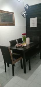 a dining room table with two chairs and a black table at AZhomestay in Jitra